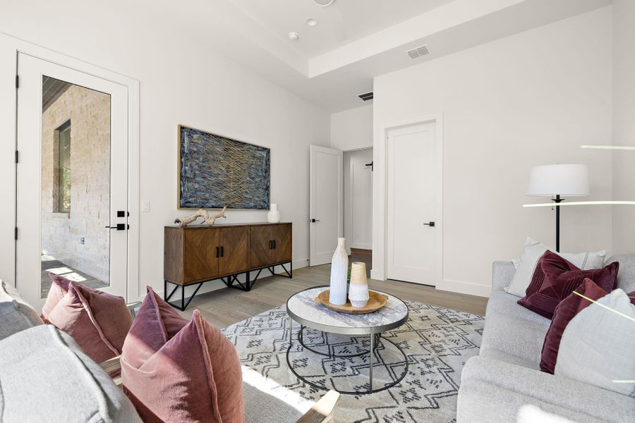 Living room with light wood-style floors, visible vents, and baseboards