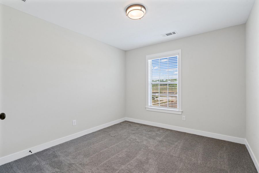 Spare room with baseboards and dark colored carpet Spare room with baseboards and dark colored carpet