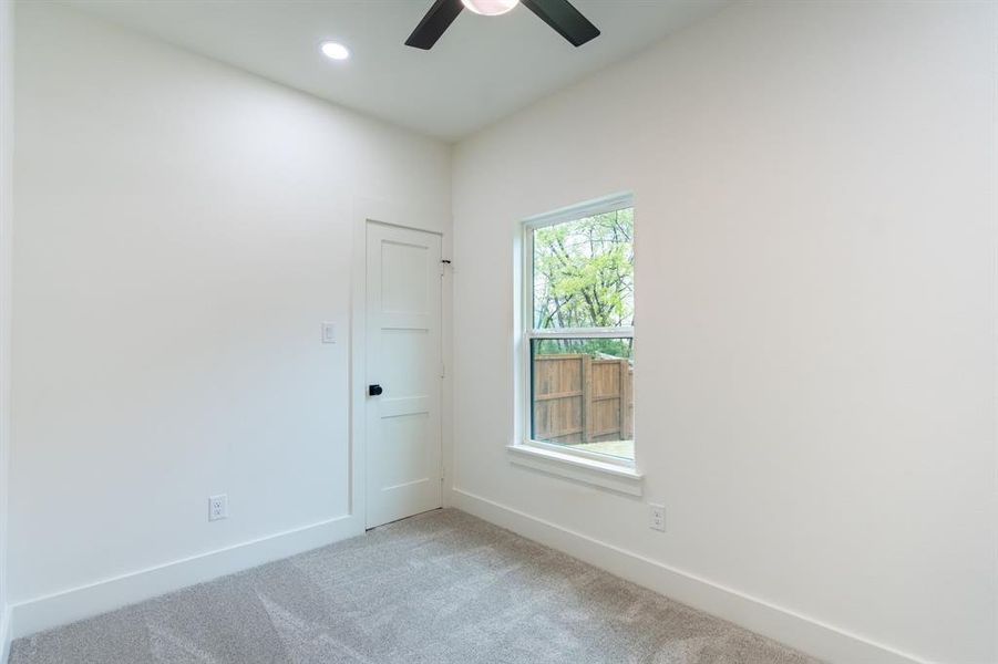 Carpeted empty room featuring ceiling fan