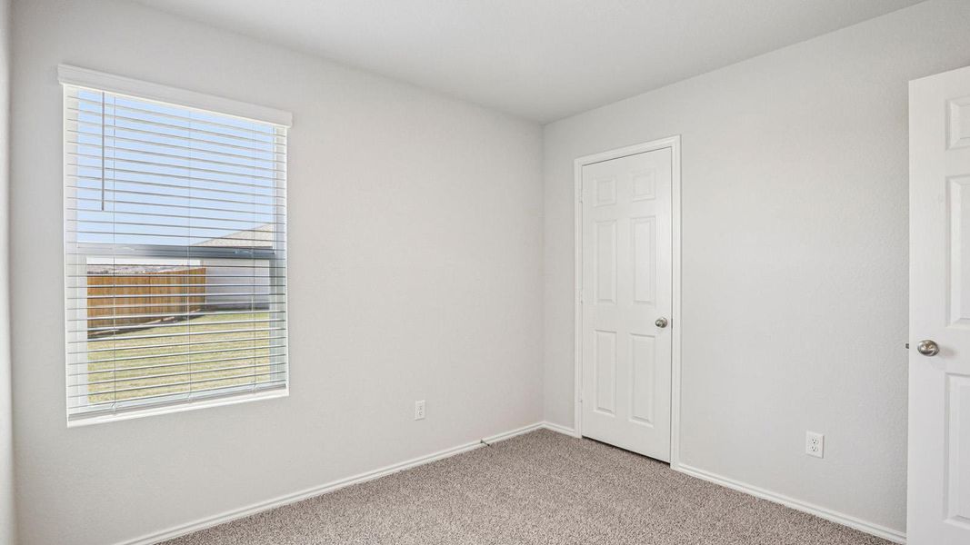 Bedroom with light gray walls, textured carpet flooring, and a window with horizontal blinds Bedroom with light gray walls, textured carpet flooring, and a window with horizontal blinds