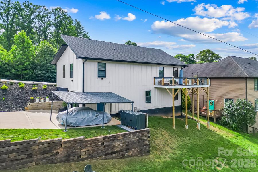 Rear of the home with view of car port