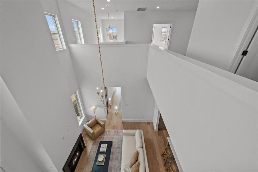 Stairs with hardwood / wood-style flooring, a high ceiling, and a notable chandelier