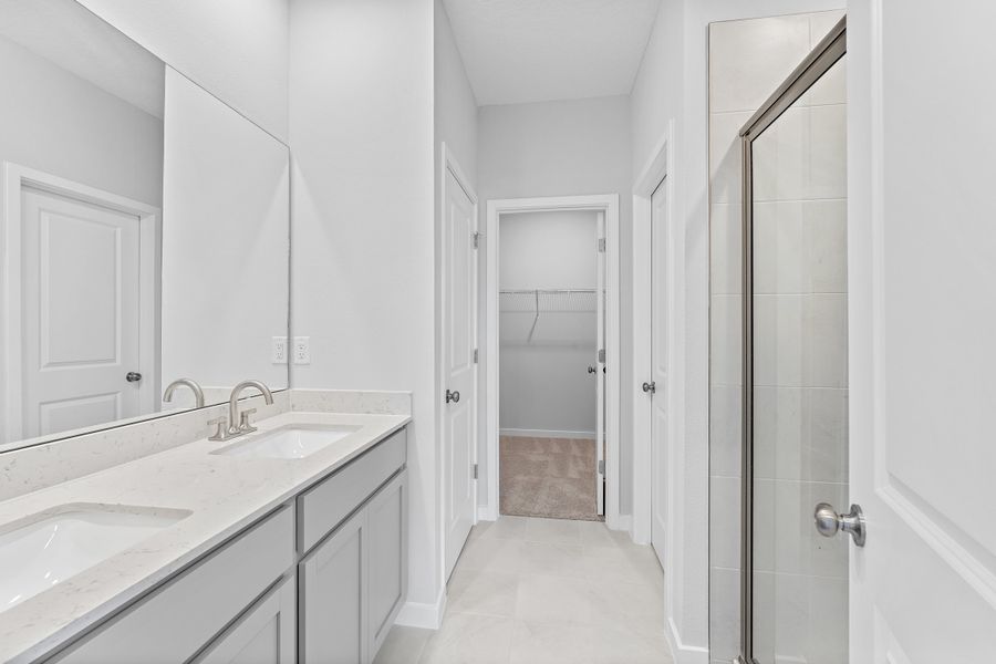 Lot 19 Cedar II Primary Bathroom with Dual Vanity Sink and Glass Shower at Camden Woods in Kingsland, GA