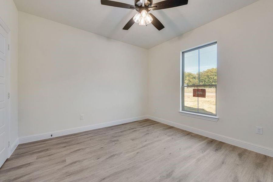 Spare room with light wood-type flooring and ceiling fan