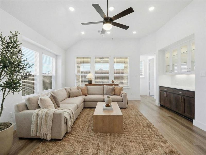Virtually Staged Living area with light wood-style floors, a ceiling fan, recessed lighting, and plenty of natural light