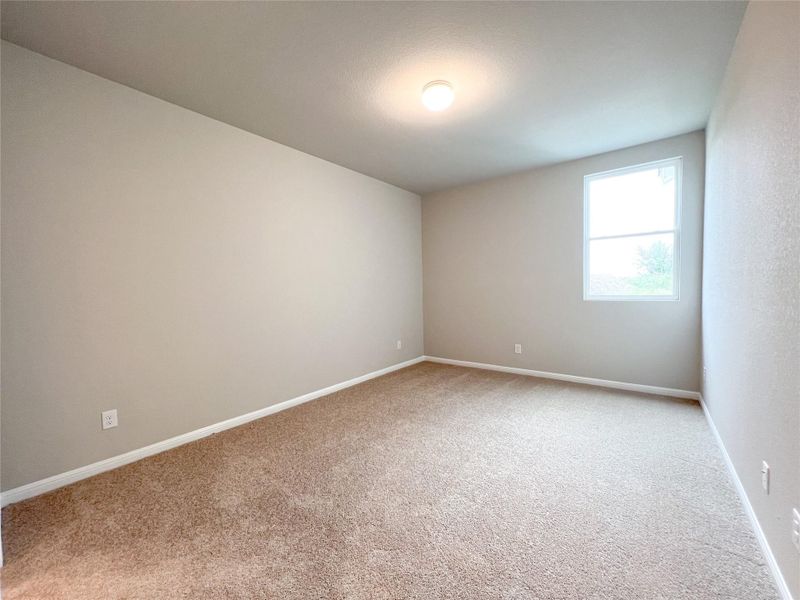 A well-lit bedroom features plush carpeting and a bright window, offering a comfortable retreat. A well-lit bedroom features plush carpeting and a bright window, offering a comfortable retreat.