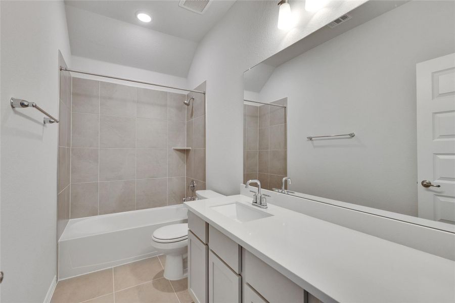 Full bath featuring bathing tub / shower combination, vanity, and light tile patterned flooring Full bath featuring bathing tub / shower combination, vanity, and light tile patterned flooring