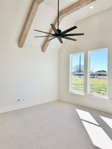 Unfurnished room featuring light carpet, vaulted ceiling with beams, and baseboards