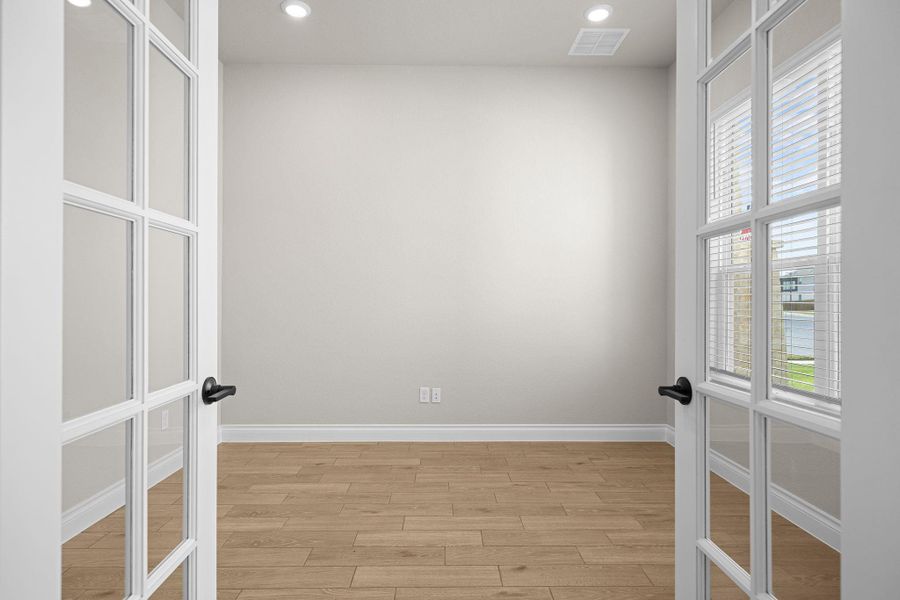 Spare room featuring french doors, light wood-type flooring, and recessed lighting