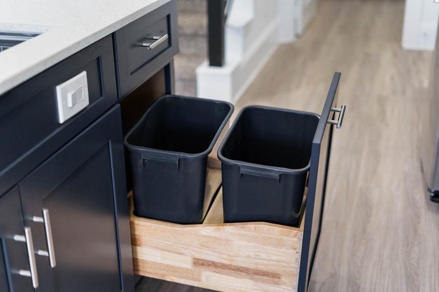 This stunning custom cabinetry even has a hidden trash drawer! Chic cabinets door and drawers' hardware and more.