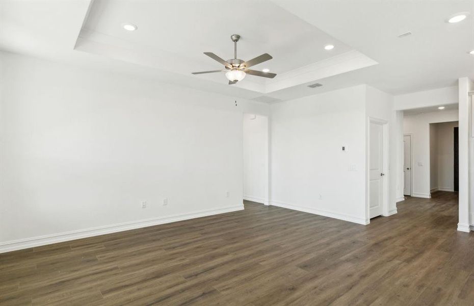 Spacious gathering room with large windows and tray ceiling *real home pictured