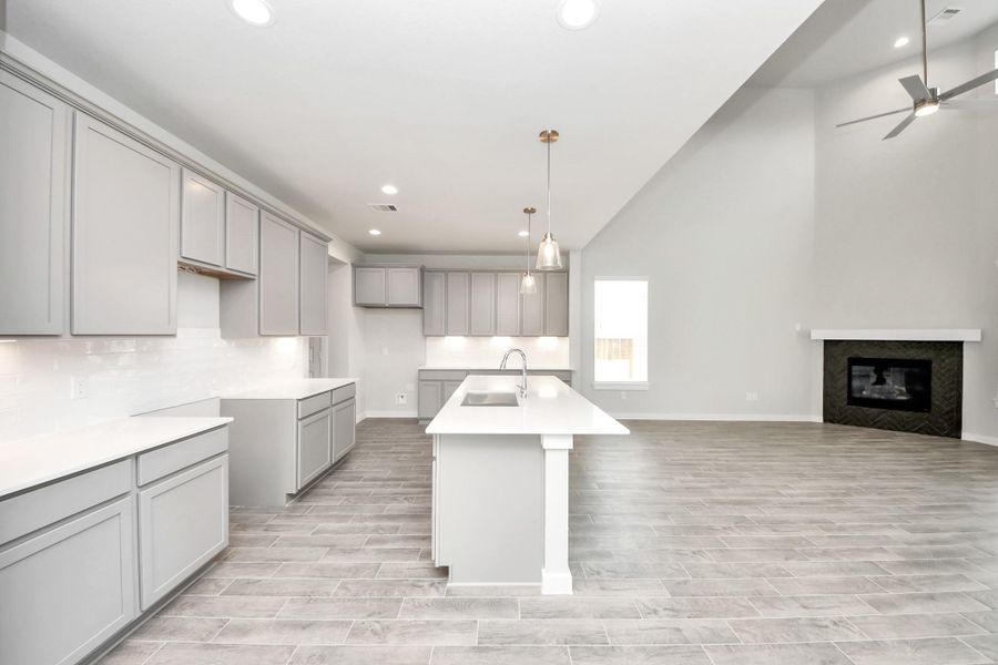 The kitchen is a culinary haven, featuring granite countertops, a tile backsplash, stainless steel appliances, 42” upper cabinets, and undercabinet lighting. Sample photo of completed home with similar floor plan. Actual colors and selections may vary. The kitchen is a culinary haven, featuring granite countertops, a tile backsplash, stainless steel appliances, 42” upper cabinets, and undercabinet lighting. Sample photo of completed home with similar floor plan. Actual colors and selections may vary.