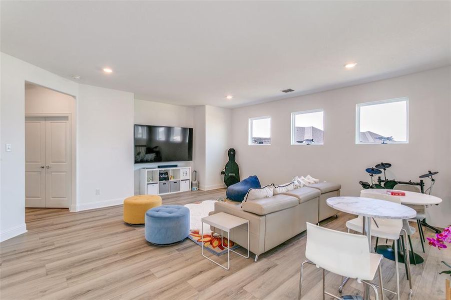 Living room featuring light wood-style flooring and recessed lighting