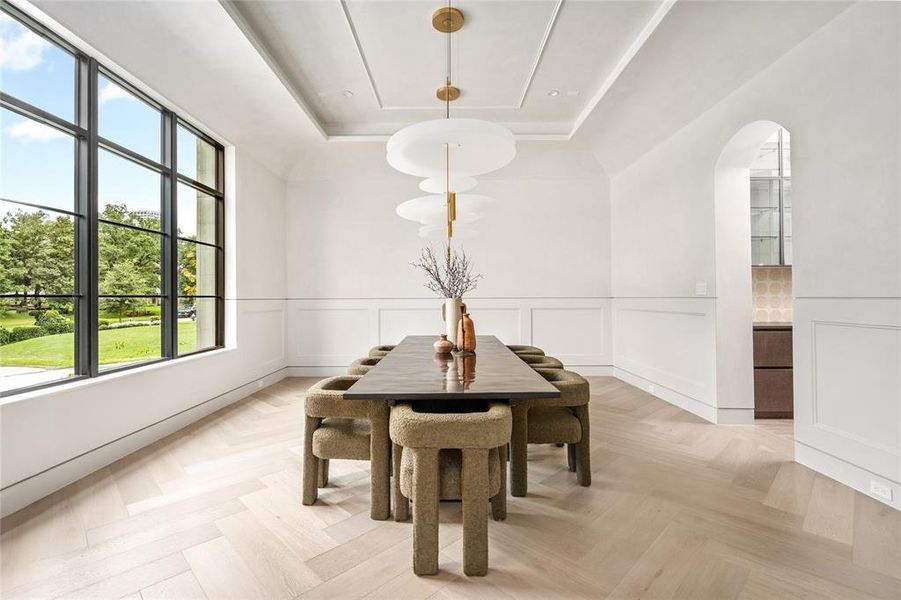 The formal dining room is bathed in natural light, creating the perfect ambiance for intimate dining experiences. The tray ceiling, adorned with modern chandeliers ensures ample illumination for all meals.