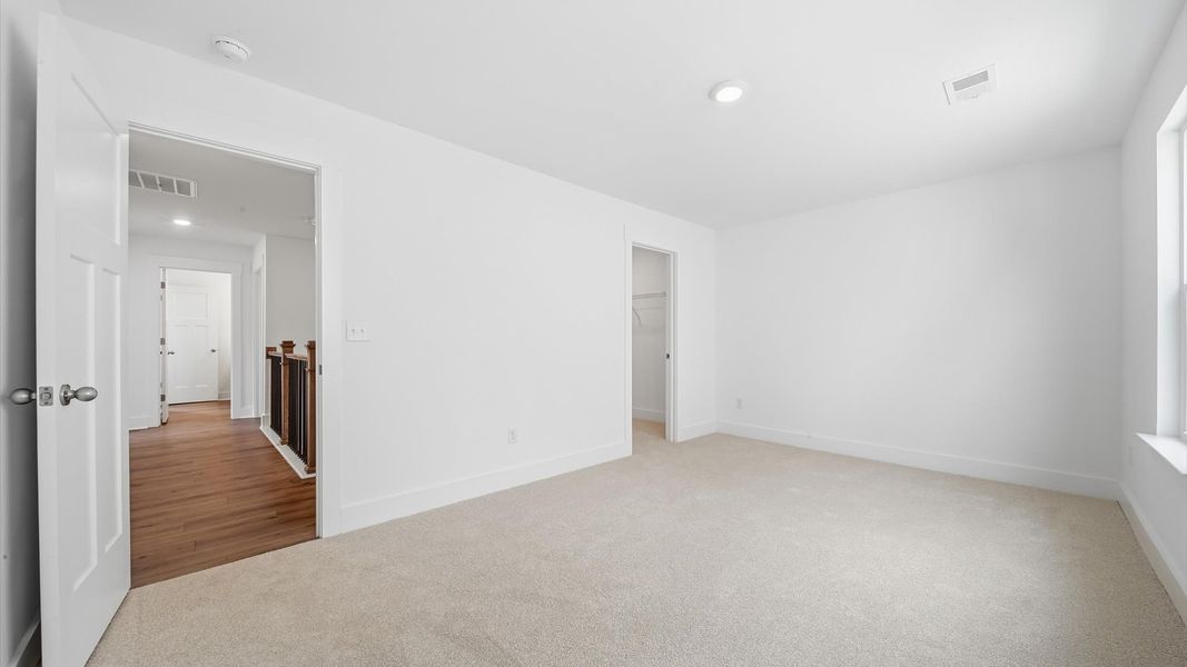 Elegant bedroom retreat featuring soft carpet and oversized windows that create a bright, welcoming space Elegant bedroom retreat featuring soft carpet and oversized windows that create a bright, welcoming space