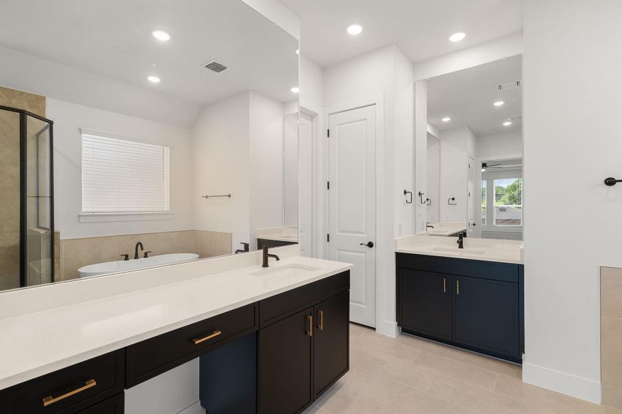 Dual vanities and a soaking tub create a luxurious primary bathroom oasis.