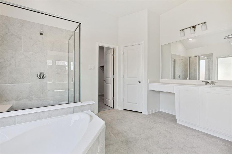 Bathroom featuring tile patterned flooring, plus walk in shower, and vanity