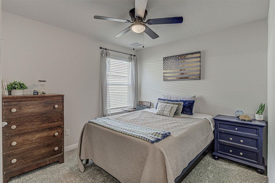 Bedroom featuring a ceiling fan and light carpet