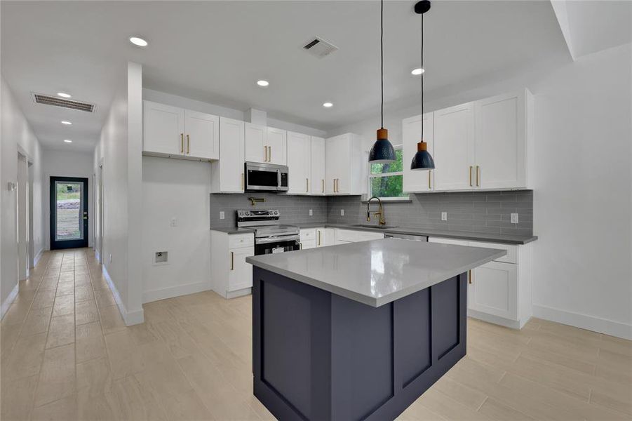 The blue island makes a great contrast to the white cabinets in the rest of the kitchen