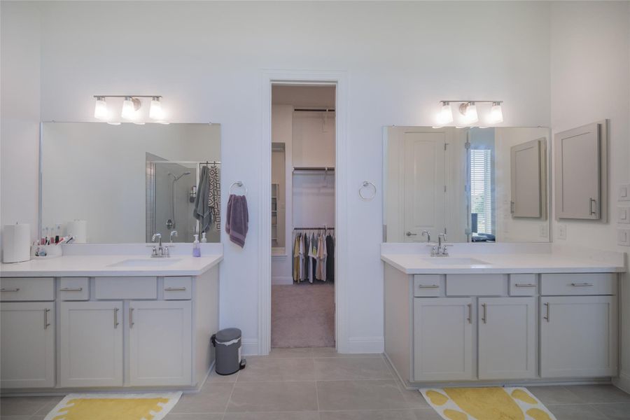 Twin vanities offer ample counter space and storage in this elegant bathroom.