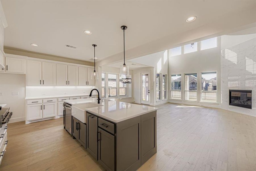 Kitchen featuring white cabinets, plenty of natural light, recessed lighting, pendant lighting, and light wood-type flooring