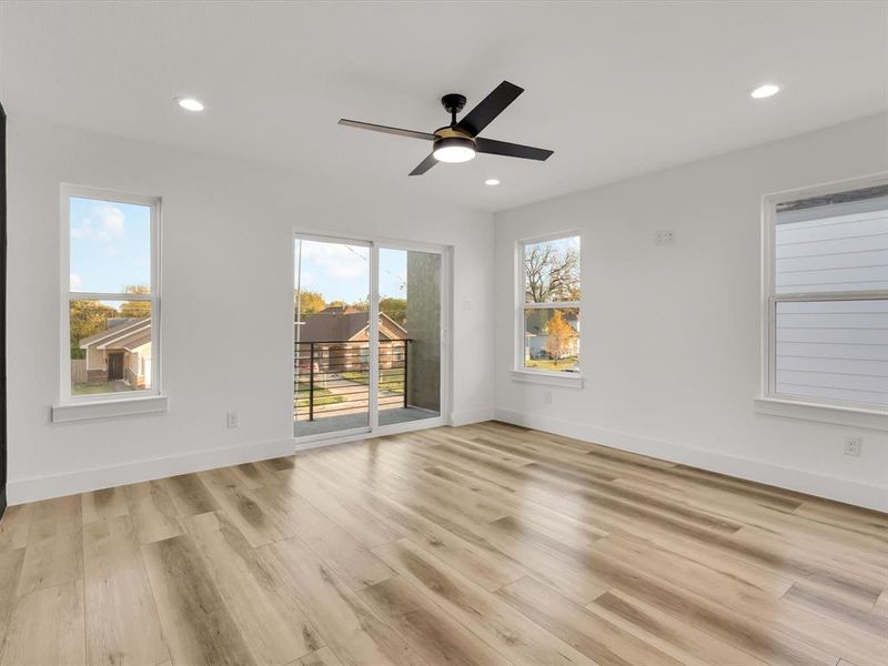 Unfurnished room featuring ceiling fan, a wealth of natural light, and light hardwood / wood-style flooring