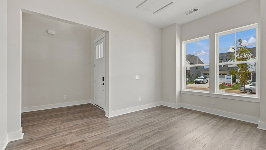 Living space view of front door and neighborhood outlook from two windows.