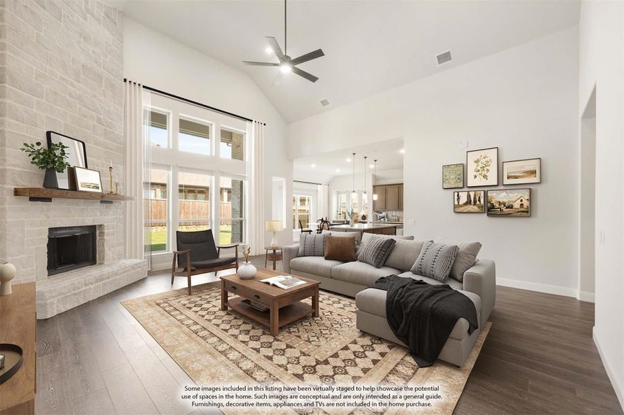 Living room with vaulted ceiling, stone fireplace, hardwood floors, and open view to kitchen Living room with vaulted ceiling, stone fireplace, hardwood floors, and open view to kitchen
