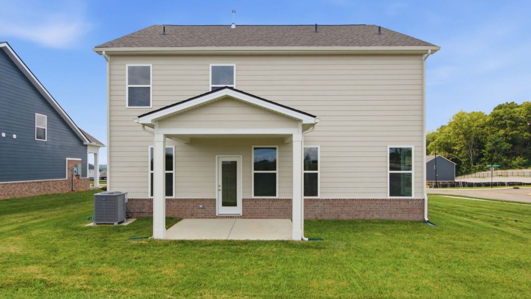 Rear exterior of home with sodded backyard