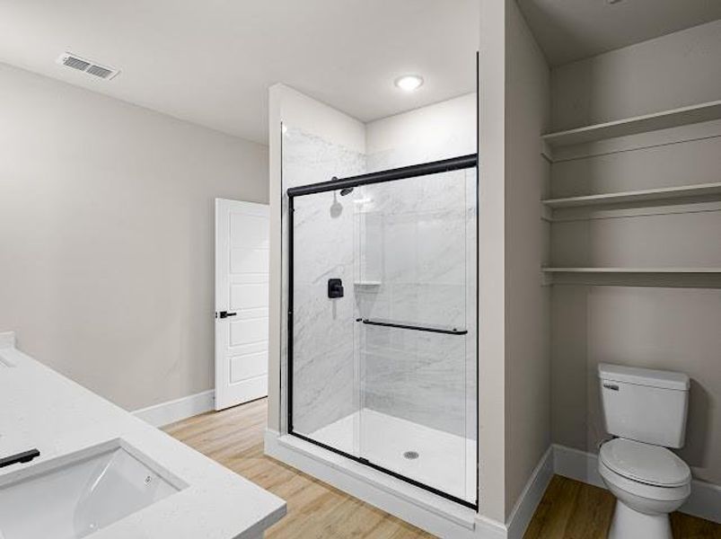 Bathroom with light wood-style floors, vanity, and a marble finish shower Bathroom with light wood-style floors, vanity, and a marble finish shower