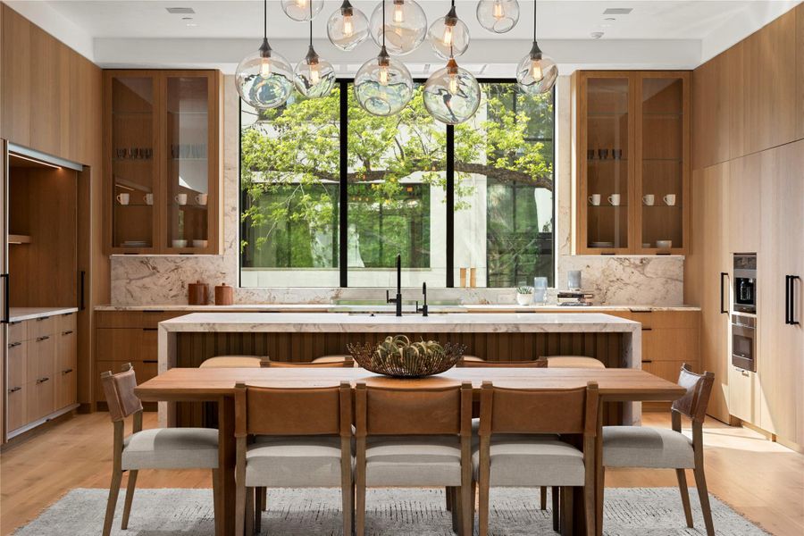 Kitchen featuring glass insert cabinets, modern cabinets, light wood-style flooring, and wood finish cabinets
