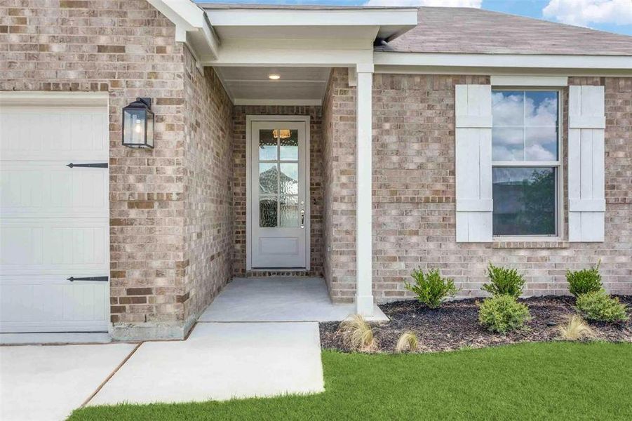 Property entrance with an attached garage and brick siding Property entrance with an attached garage and brick siding