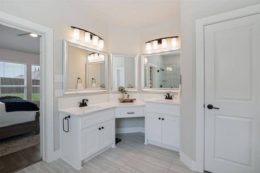 Dual vanities with white cabinetry and integrated sinks, complemented by a central makeup vanity