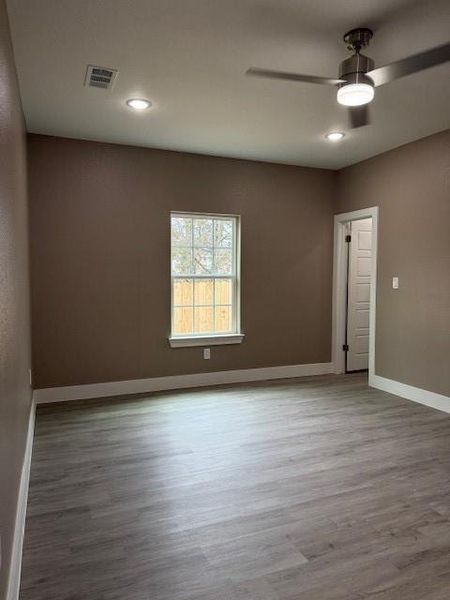 Spacious interior featuring wood-finish flooring, neutral wall tones, recessed lighting, and a contemporary ceiling fan