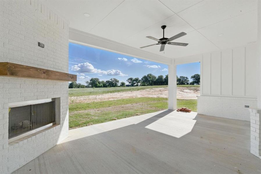 View of patio featuring a ceiling fan and an outdoor brick fireplace View of patio featuring a ceiling fan and an outdoor brick fireplace