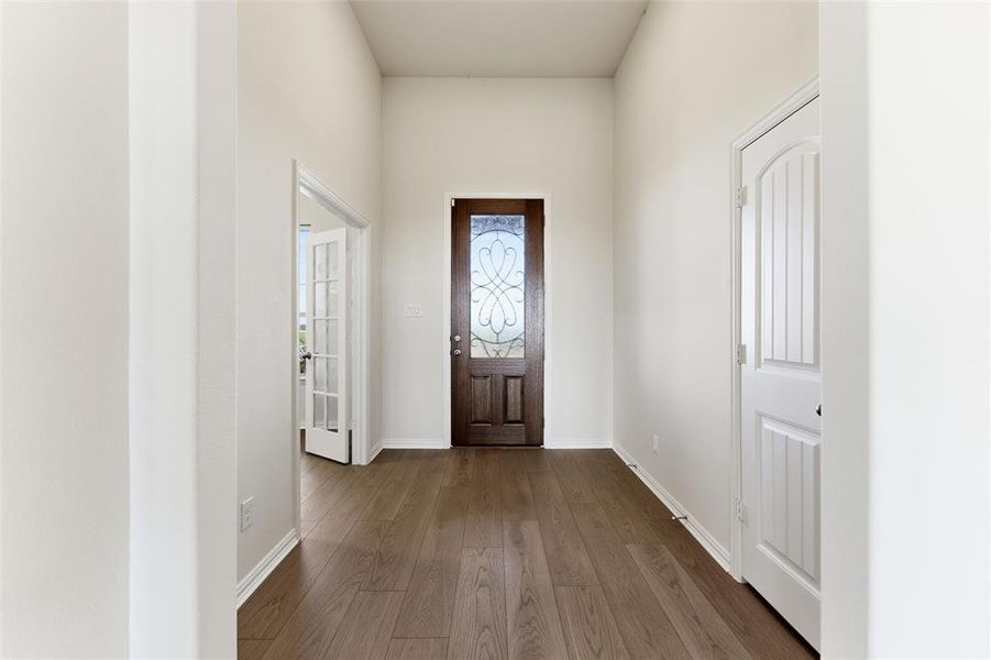 Entryway with dark wood-type flooring and baseboards