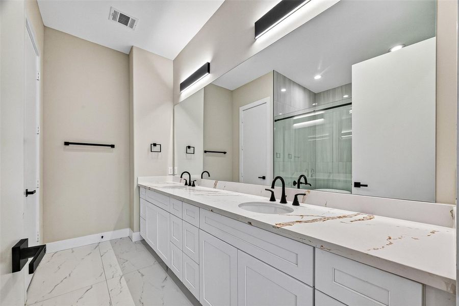 Spacious primary bathroom featuring a double vanity with ample counter space. Spacious primary bathroom featuring a double vanity with ample counter space.