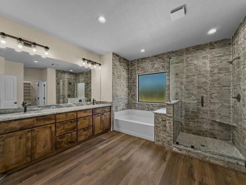 Bathroom featuring a shower stall, a garden tub, double vanity, and wood finished floors Bathroom featuring a shower stall, a garden tub, double vanity, and wood finished floors