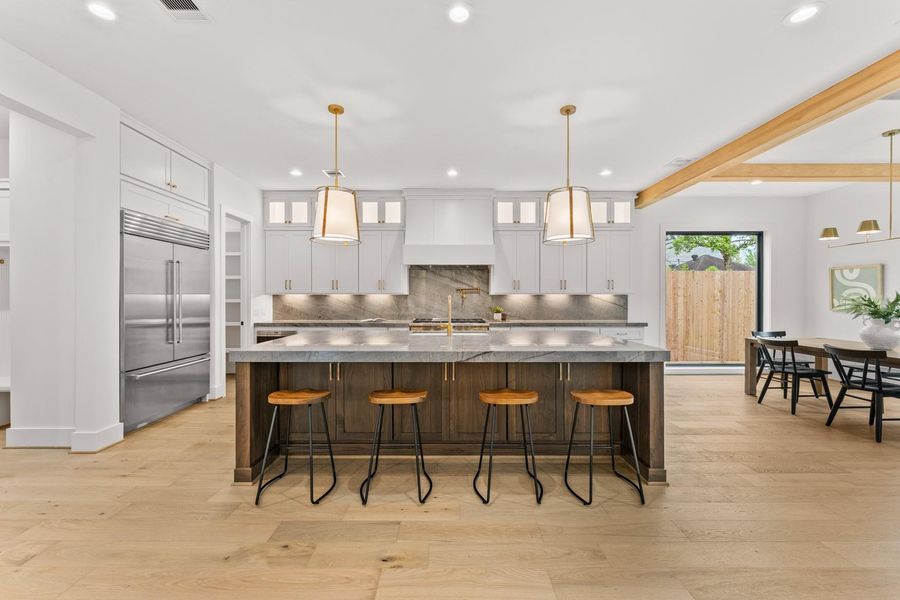 Oversized quartzite island, Sub-Zero fridge, and Wolf six burner range