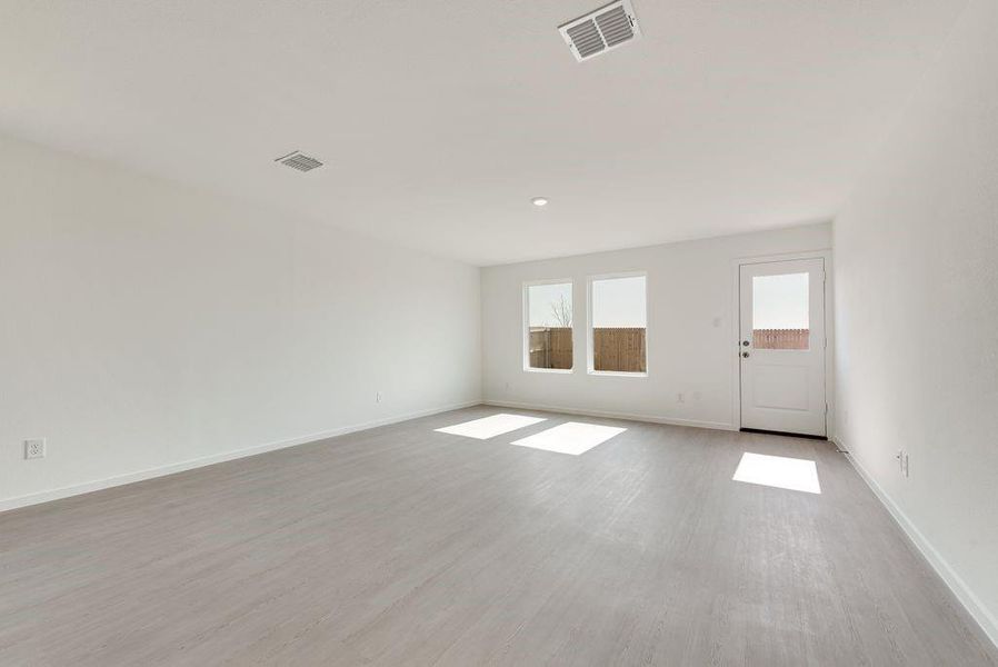 Unfurnished room with baseboards, visible vents, and wood finished floors