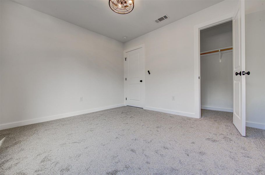 Unfurnished bedroom featuring a closet and light carpet