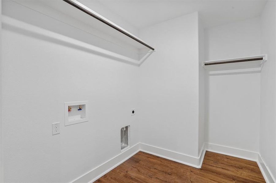 Clothes washing area with hookup for a washing machine, wood finished floors, baseboards, hookup for an electric dryer, and laundry area