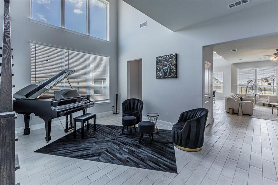 Sitting room with light Ceramic Tile flooring, a ceiling fan, and a high ceiling Sitting room with light Ceramic Tile flooring, a ceiling fan, and a high ceiling