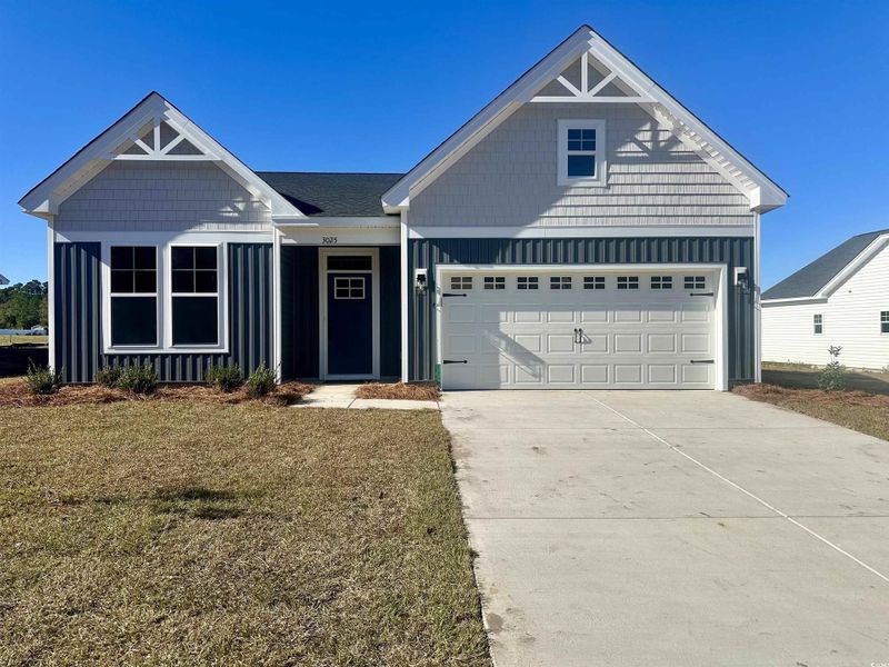 View of front of home featuring board and batten siding, concrete driveway, and a front yard View of front of home featuring board and batten siding, concrete driveway, and a front yard