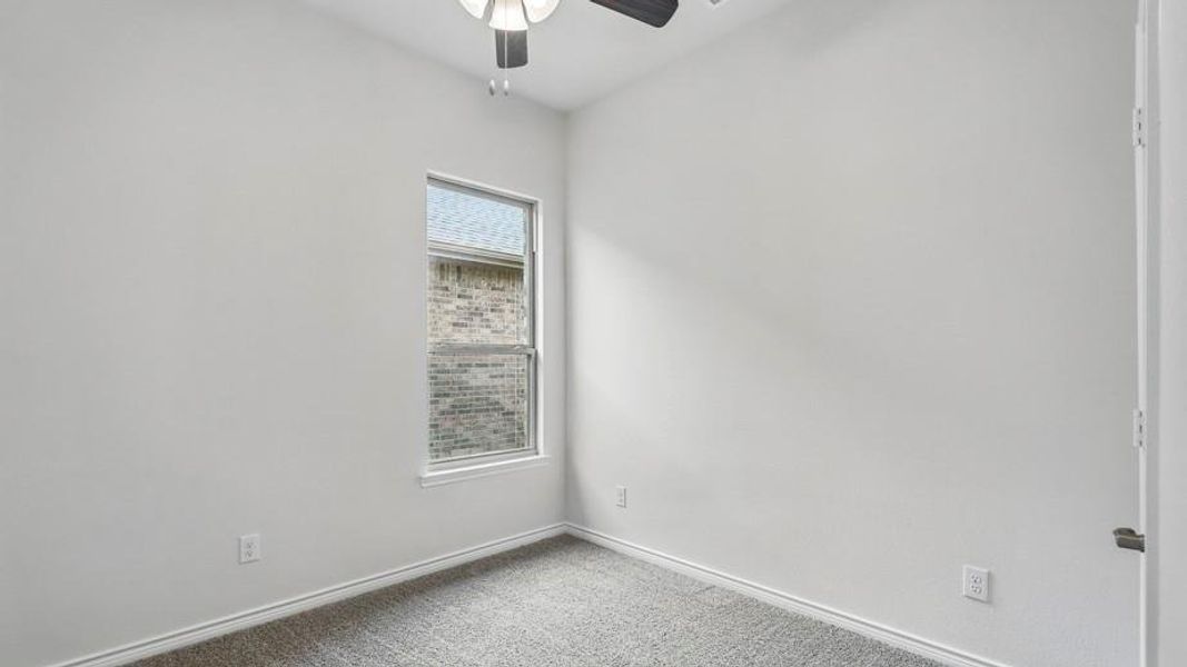 Neutral-toned room with a single window, light gray carpeting, and white baseboards