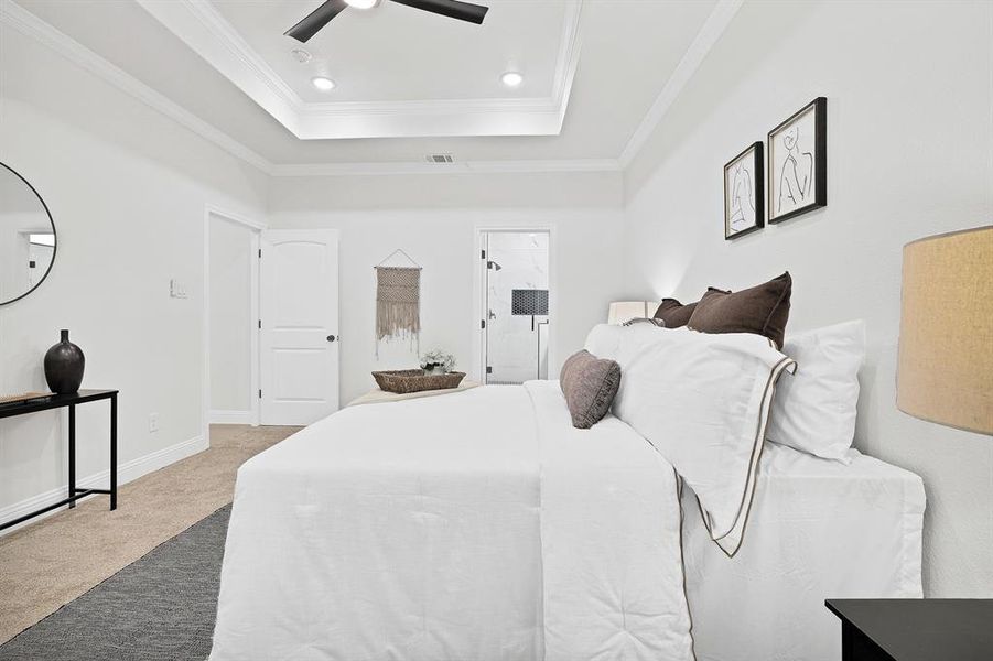 Bedroom with carpet flooring, ceiling fan, crown molding, and a tray ceiling