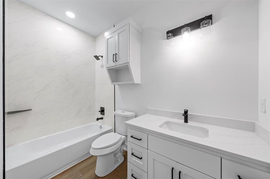 Bathroom featuring vanity, wood finished floors, tub / shower combination, and recessed lighting Bathroom featuring vanity, wood finished floors, tub / shower combination, and recessed lighting