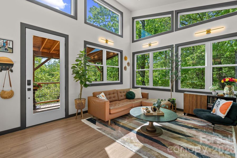 Step inside from the covered deck and find yourself surrounded by a wall of windows inside a lush canopy.