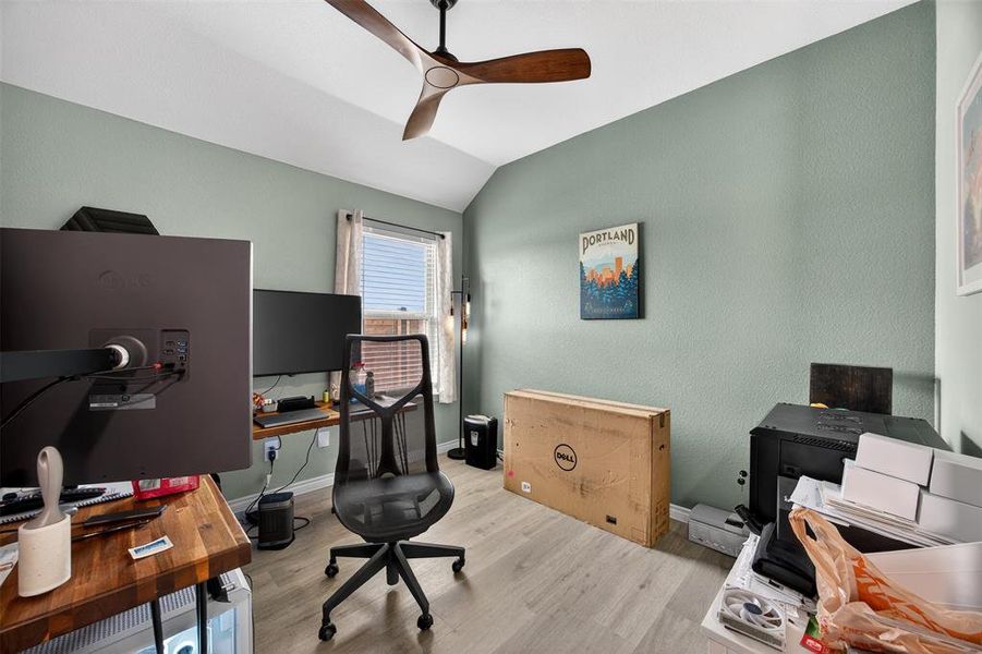 Office area with a ceiling fan, lofted ceiling, and light wood-type flooring