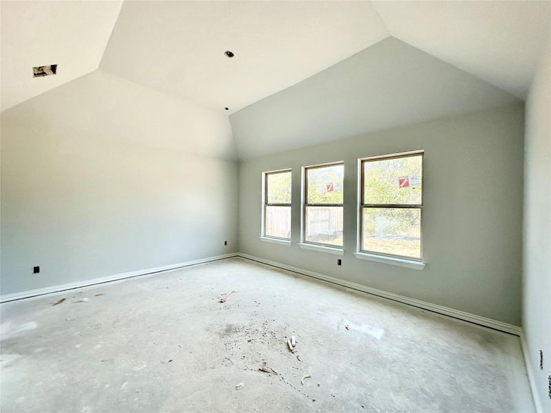 Unfurnished room with vaulted ceiling and baseboards Unfurnished room with vaulted ceiling and baseboards